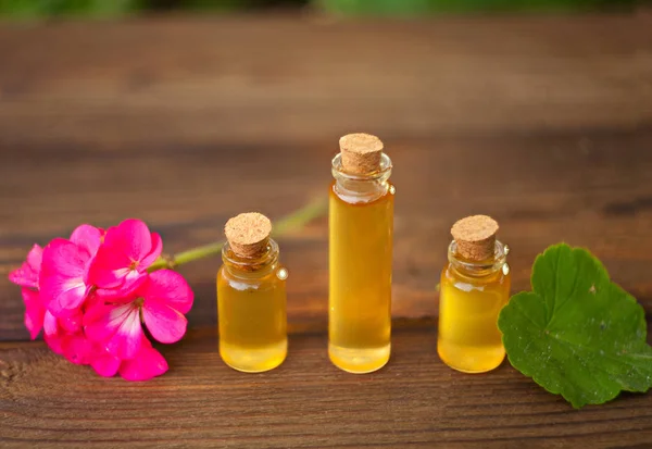 Esencia de flores en la mesa en un hermoso frasco de vidrio — Foto de Stock