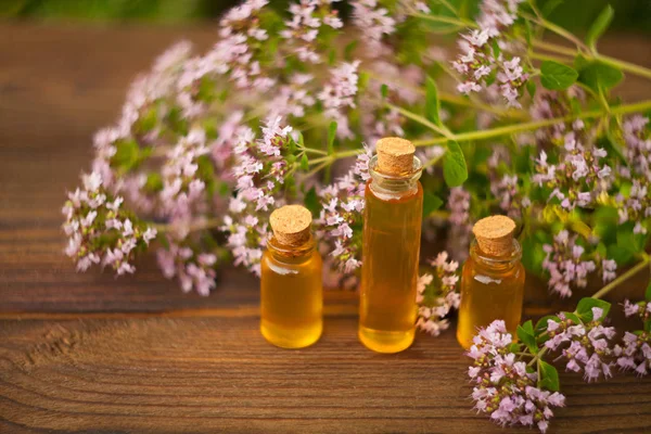 Esencia de flores de lavanda en la mesa en una hermosa botella de vidrio — Foto de Stock