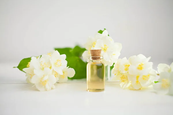 Esencia de flores en la mesa en un hermoso frasco de vidrio — Foto de Stock