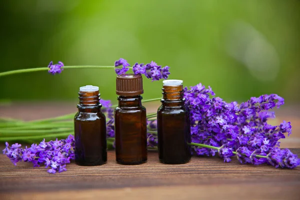 Essence of lavender flowers on table in beautiful glass jar — Stock Photo, Image