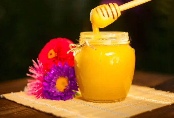 Delicious delicious honey in  jar on table