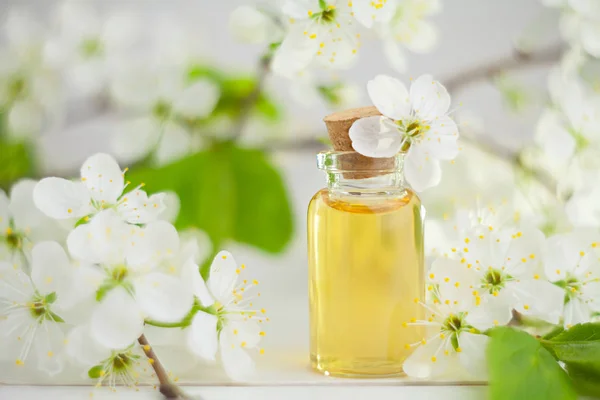 Esencia de flores en la mesa en un hermoso frasco de vidrio — Foto de Stock