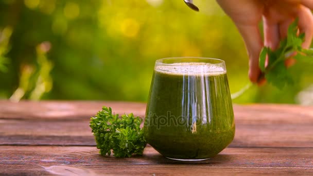 Jus de persil et céleri en verre sur une table en bois — Video