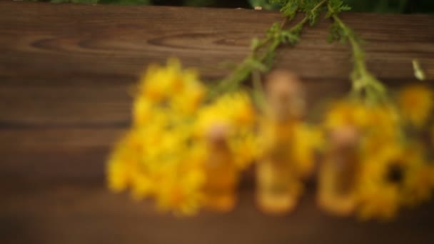 Etherische olie op tafel in mooie fles met bloemen — Stockvideo