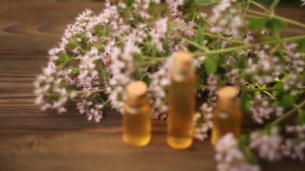 Есенція квітів на столі в красивій скляній пляшці — стокове відео