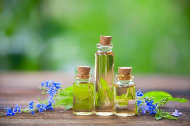 Çiçeklerin özü güzel bir cam şişede masanın üzerinde.