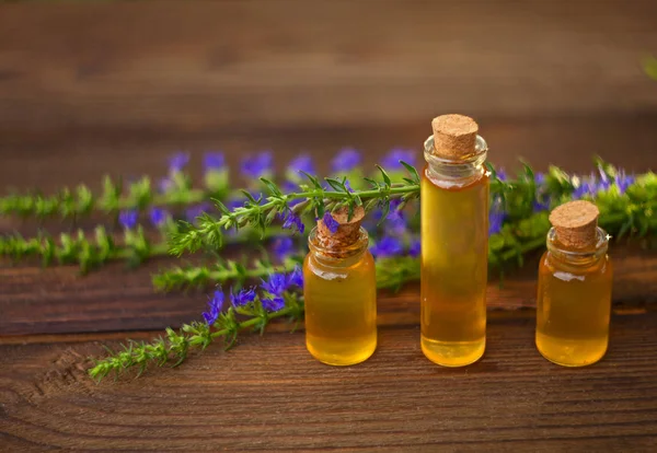 Esencia de flores de lavanda en la mesa en una hermosa botella de vidrio — Foto de Stock