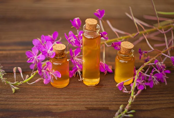 Esencia de flores de lavanda en la mesa en una hermosa botella de vidrio —  Fotos de Stock