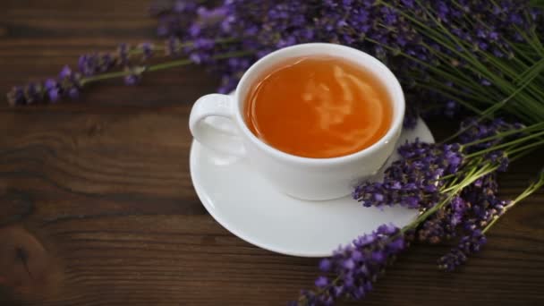 Вкусный зеленый чай в красивой стеклянной чаше на столе — стоковое видео