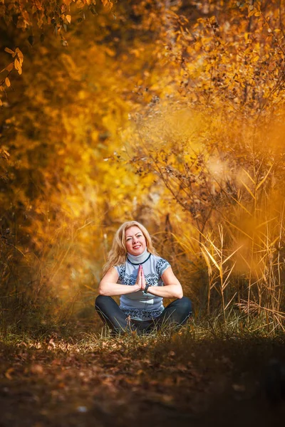 Όμορφη γυναίκα να κάνει γιόγκα σε εξωτερικούς χώρους σε κίτρινα φύλλα — Φωτογραφία Αρχείου