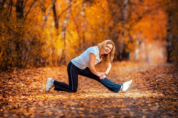 Femeie frumoasă care face yoga în aer liber în toamnă — Fotografie, imagine de stoc