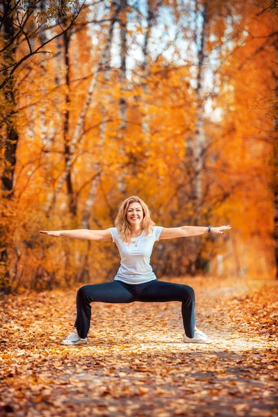 Femeie frumoasă care face yoga în aer liber în toamnă — Fotografie, imagine de stoc