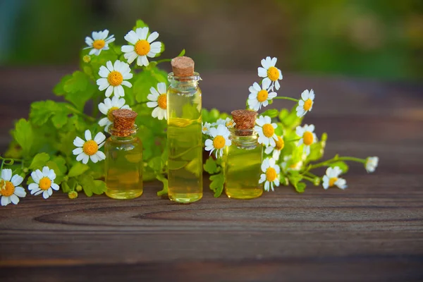 Essentie van bloemen op tafel in mooie glazen fles — Stockfoto