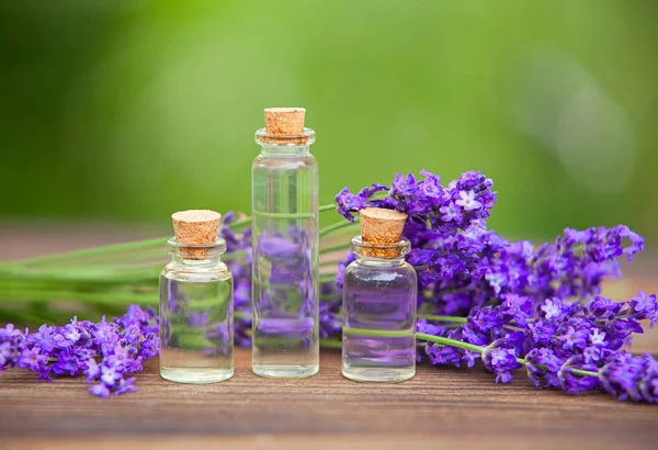 Aceite esencial de lavanda en una hermosa botella sobre la mesa — Foto de Stock