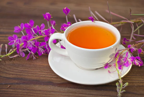 Finom tűzfű tea egy gyönyörű üveg tál az asztalon — Stock Fotó