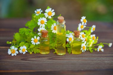 Çiçeklerin özü güzel bir cam şişede masanın üzerinde.