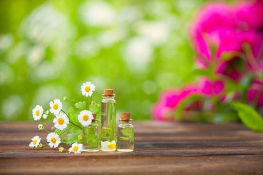 Essence of flowers on table in beautiful glass bottle clipart