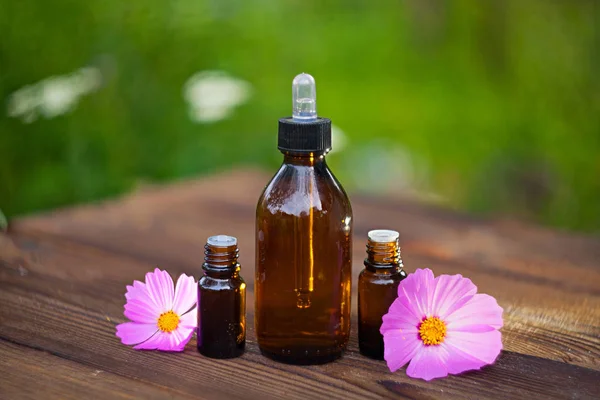 Essence of  flowers on table in beautiful glass Bottle — Stock Photo, Image