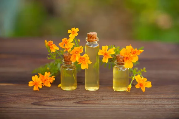 Goudsbloem etherische olie in mooie fles op tafel — Stockfoto