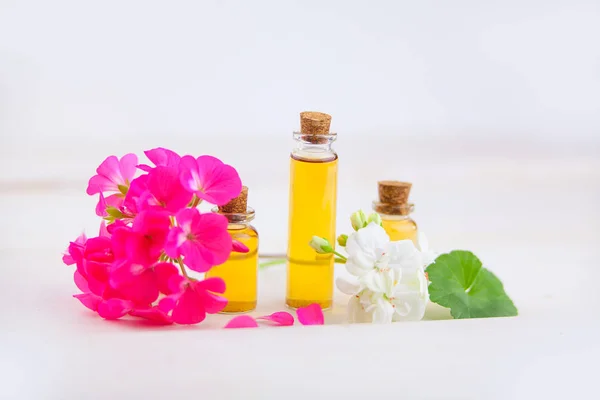 Esencia de flores en la mesa en un hermoso frasco de vidrio — Foto de Stock