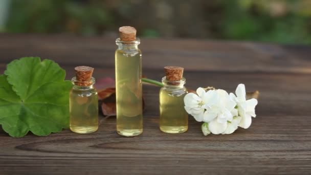 Esencia de flores en la mesa en un hermoso frasco de vidrio — Vídeos de Stock