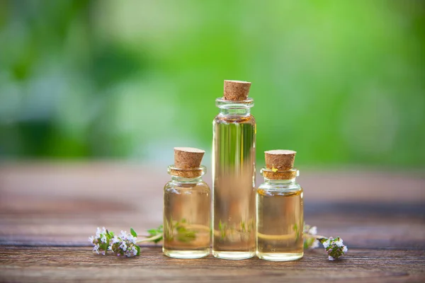 Tijm etherische olie in mooie fles op tafel — Stockfoto