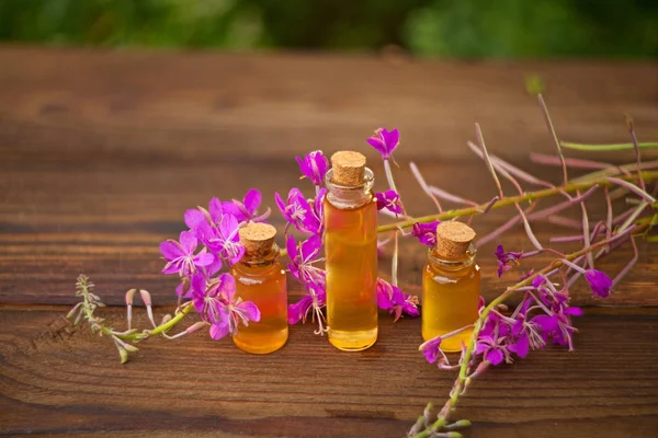 Esencia de flores de lavanda en la mesa en una hermosa botella de vidrio —  Fotos de Stock