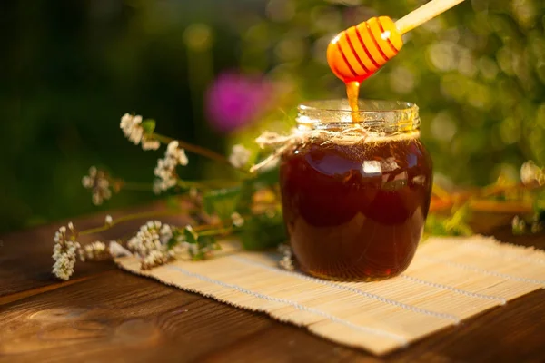 Deliciosa y deliciosa miel en frasco sobre la mesa — Foto de Stock