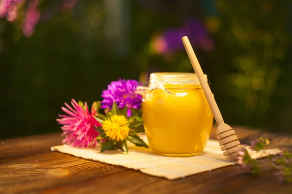 Deliciosa y deliciosa miel en frasco sobre la mesa — Foto de Stock