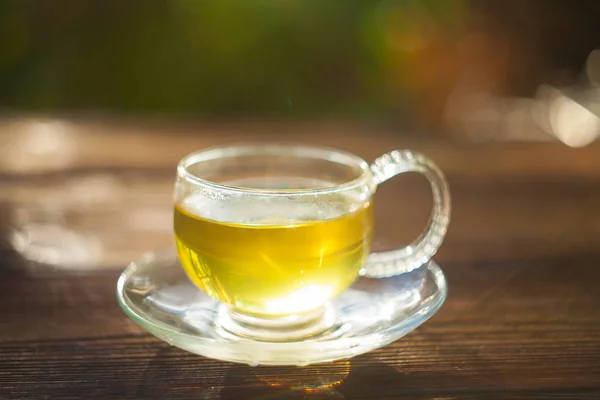 Köstlicher grüner Tee in schöner Glasschale auf dem Tisch — Stockfoto