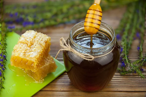 Deliciosa y deliciosa miel en frasco sobre la mesa — Foto de Stock