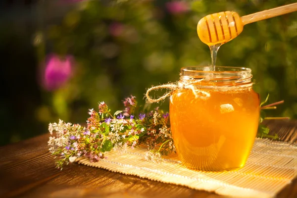 Deliciosa y deliciosa miel en frasco sobre la mesa — Foto de Stock