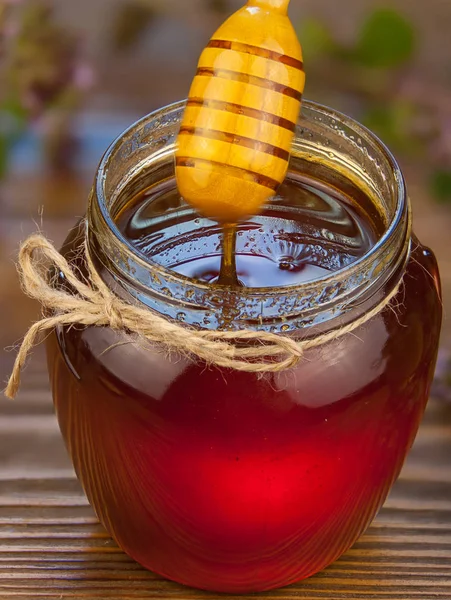 Deliciosa y deliciosa miel en frasco sobre la mesa — Foto de Stock
