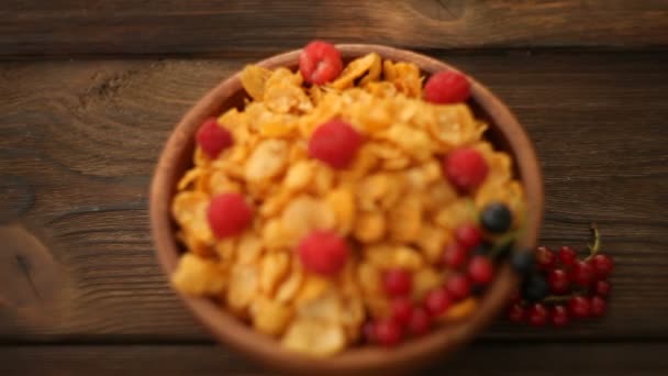 Breakfast of cornflakes with berries in wooden bowl — Stock Video
