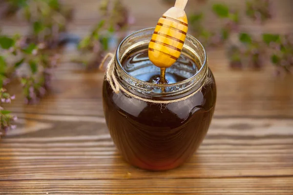 Läckra läckra honung i burken på bordet — Stockfoto