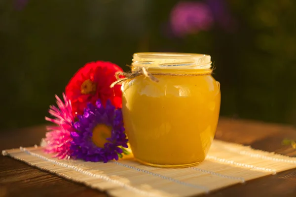 Deliciosa y deliciosa miel en frasco sobre la mesa —  Fotos de Stock