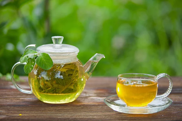 Délicieux thé vert dans un beau bol en verre sur la table — Photo