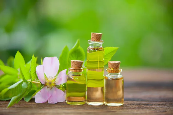 Esencia de flores en la mesa en un hermoso frasco de vidrio — Foto de Stock