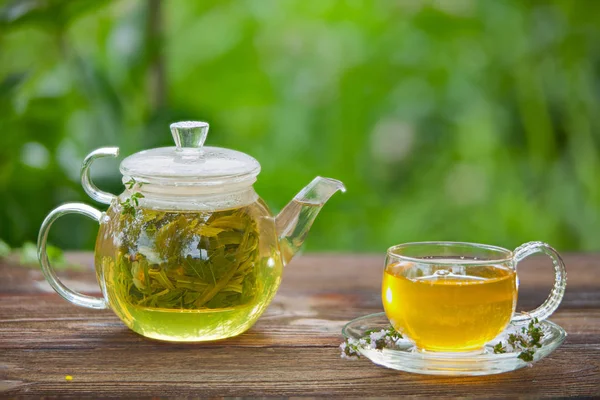 Delicioso té verde en un hermoso tazón de vidrio en la mesa — Foto de Stock