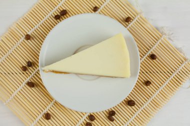 Beyaz masa üzerinde beyaz tabakta klasik cheesecake