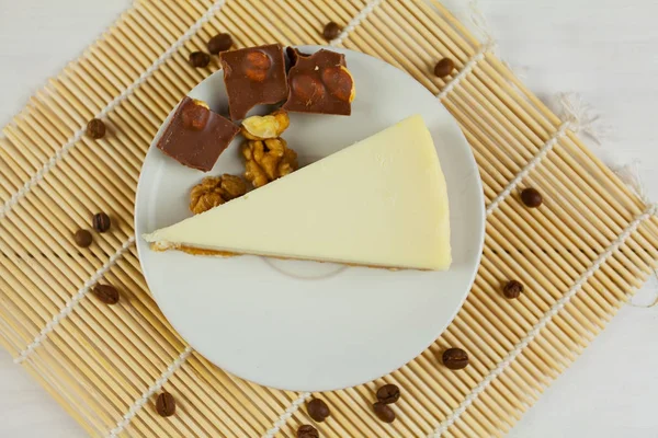 Klasický cheesecake na bílém štítku na bílém stole — Stock fotografie