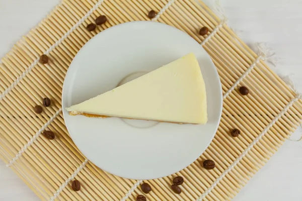 Klasický cheesecake na bílém štítku na bílém stole — Stock fotografie