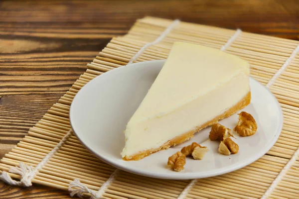 Klasický cheesecake na bílém štítku na dřevěný stůl — Stock fotografie