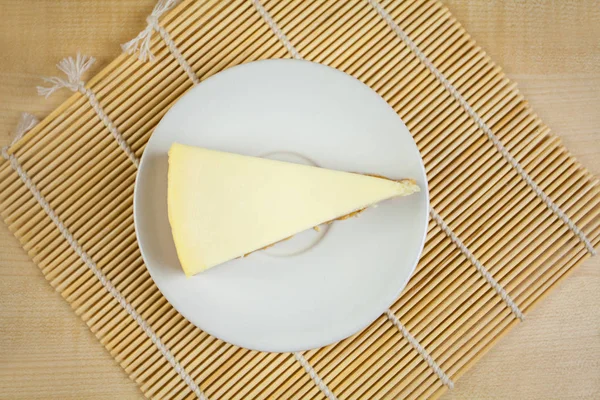 Classic cheesecake on white plate on  wooden table — Stock Photo, Image