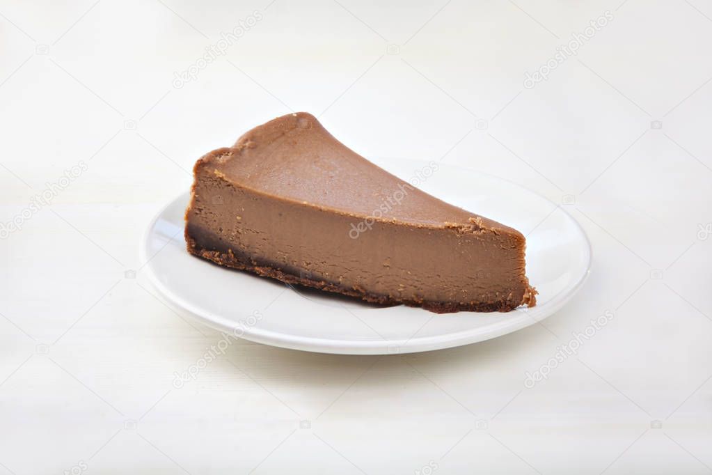 chocolate cheesecake on white plate on  wooden table