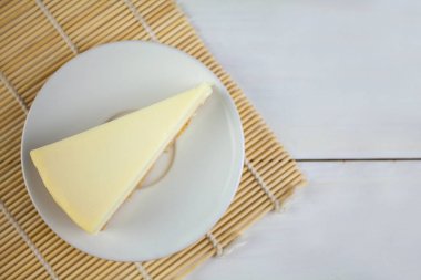 Beyaz masa üzerinde beyaz tabakta klasik cheesecake