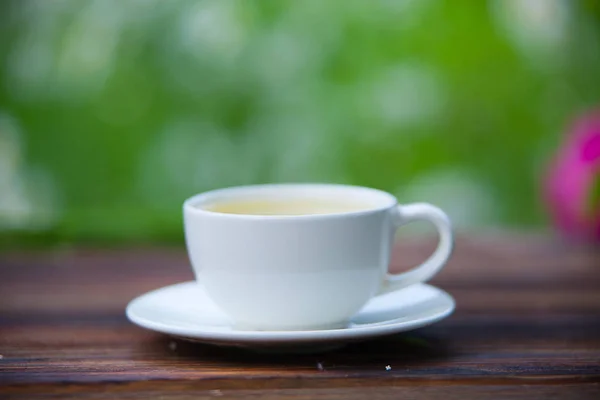 Taza de porcelana con té verde en la mesa — Foto de Stock