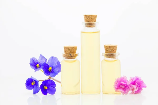 Aceite esencial violeta en hermosa botella sobre fondo blanco — Foto de Stock