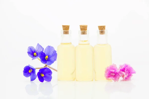 Óleo essencial violeta em bela garrafa no fundo branco — Fotografia de Stock