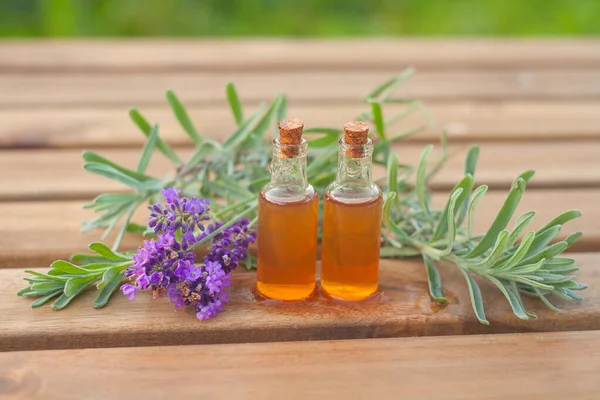 Aceite esencial de lavanda en una hermosa botella sobre la mesa — Foto de Stock